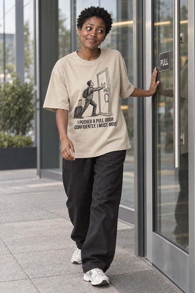 The shirt worn at a glass office entrance, one hand flat on the door beside a PULL plate