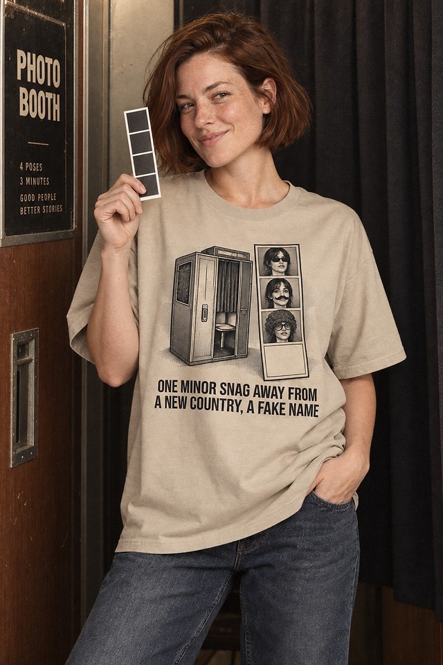 The shirt worn beside a photo-booth curtain, holding up a fresh strip of portraits